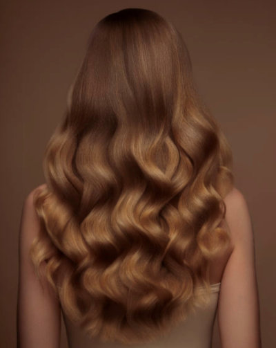 Woman with golden blonde long wavy hair viewed from behind