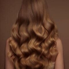 Woman with golden blonde long wavy hair viewed from behind