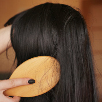 Hand holding a new wig and brushing hair